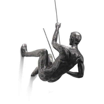 Sculpture murale représentant un personnage en train de grimper