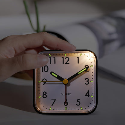 Travel alarm clock with luminous hands